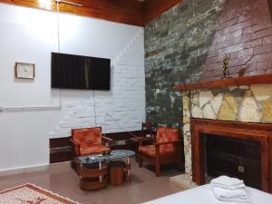a living room with a fireplace and a tv at Guest House Univers in Berat