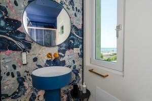 a bathroom with a mirror and a sink at La Caravella in Loano +37 photos