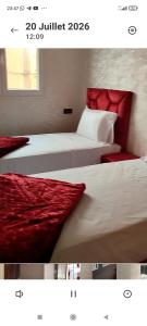 two beds with red pillows in a room at Résidence Hala in Tan-Tan