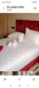 a bed with white sheets and pillows on it at Résidence Hala in Tan-Tan +6 photos