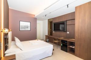 a hotel room with a bed and a flat screen tv at La Caravella in Loano