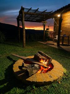 a fire pit with two knives on top of it at Chalé Recanto da Cuesta in Botucatu