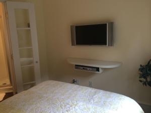a bedroom with a bed and a tv on the wall at Riverview Organic Bed & Breakfast and Wellness Center in Piermont