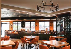 a restaurant with tables and chairs and a bar at Ramada by Wyndham Surrey/Langley in Langley