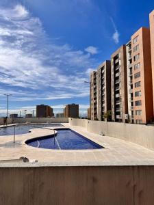 a swimming pool in the middle of a building with tall buildings at Apto acogedor en Ibague in Ibagué