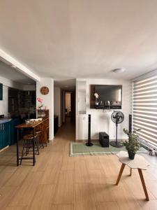 a living room with a table and a kitchen at Apto acogedor en Ibague in Ibagué