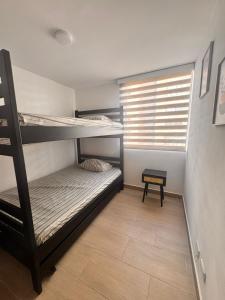 a room with two bunk beds and a window at Apto acogedor en Ibague in Ibagué