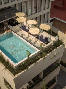 an overhead view of a swimming pool with chairs and umbrellas at Brada Collection Vendôme in Guadalajara