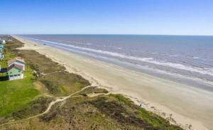 an aerial view of a beach with a house and the ocean at Sandy Beach Retreat and Gulf View in Galveston
