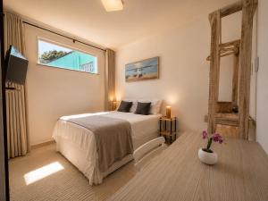 a bedroom with a bed and a window and a table at Pousada Bella Boipeba in Ilha de Boipeba