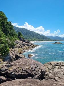 a view of the ocean from a rocky shore at Flat Esmeralda Juquehy in São Sebastião
