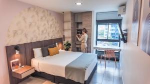a woman taking a picture of a hotel room at Hotel Molinos by Growing Group in Medellín