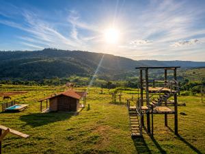 a view of a field with a playground and a house at Chalé Recanto da Cuesta in Botucatu +8 photos