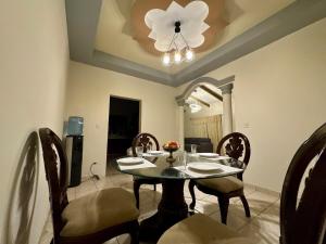 a dining room with a table and chairs and a chandelier at Luxurious Platinum House 3VX in San Pedro Sula