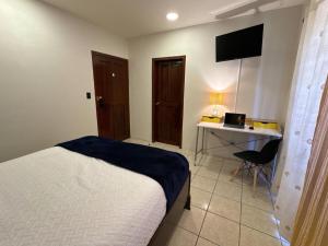 a bedroom with a bed and a desk with a laptop at Luxurious Platinum House 3VX in San Pedro Sula