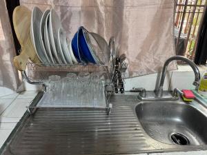 a kitchen sink with plates and glasses in a rack at Luxurious Platinum House 3VX in San Pedro Sula +33 photos