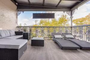 a patio with a couch and tables on a deck at William Arnott Boutique Accommodation in Morpeth