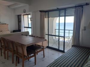 a living room with a table and a view of the ocean at Mirador Azul Las Grutas in Las Grutas +9 photos