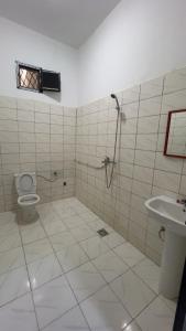 a bathroom with a shower and a toilet and a sink at Chez YaZ in Nouakchott