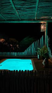 a large blue swimming pool in a dark room at São Francisco Ecopousada in Guriú