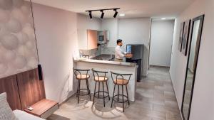a man standing at a counter in a kitchen at Hotel Molinos by Growing Group in Medellín +31 photos