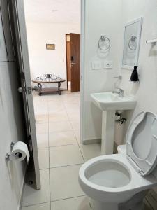 a white bathroom with a toilet and a sink at Departamento iluminado ideal para descansar in Miranda