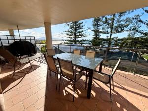 a table and chairs on a balcony with a view at Northpoint Apartment 5 - Bring your own linen. in South West Rocks