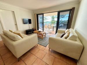a living room with two couches and a balcony at Northpoint Apartment 5 - Bring your own linen. in South West Rocks