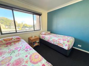 a room with two beds and a window at Northpoint Apartment 5 - Bring your own linen. in South West Rocks