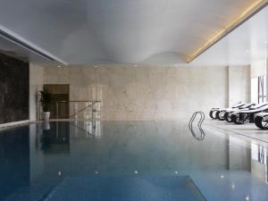 a large swimming pool in a building with a swimming pool at 太原富力铂尔曼大酒店 in Taiyuan