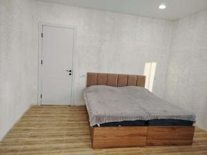 a bedroom with a bed and a white wall at gulelebi in Tʼianetʼi