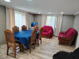 a dining room with a blue table and chairs at gulelebi in Tʼianetʼi