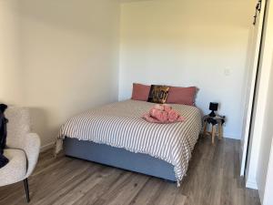 a bedroom with a bed and a chair at Hanger Ridge Cabin in Goodger