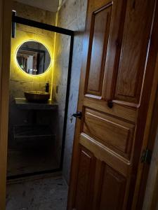 a bathroom door with a mirror and a sink at Cabaña el roble, Mazamitla Jalisco in Mazamitla