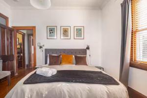a bedroom with a large bed with orange pillows at William Arnott Boutique Accommodation in Morpeth