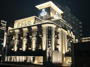a building with a sign on top of it at night at ホテル侘 in Himeji