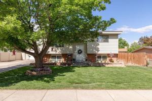 a house with a tree in the yard at Fly Away Home in West Jordan