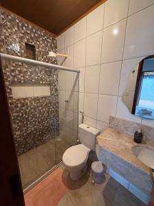 a bathroom with a toilet and a shower and a sink at Studio Praia do Chapéu in Mata de Sao Joao