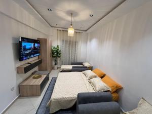a living room with a bed and a tv at Suite cobalt suite nova suite évasion in Mostaganem
