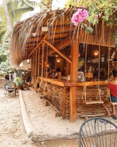 a woman sitting in front of a bar on the beach at Oceanfront, AC and Parking, La Punta in Paso Hondo