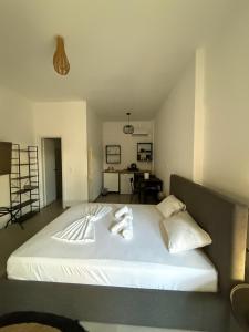 a large white bed with two towels on it at Coconut beach villas 4 in Schinias