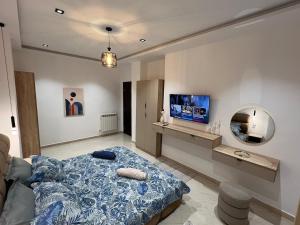 a bedroom with a bed and a mirror and a tv at Suite cobalt suite nova suite évasion in Mostaganem