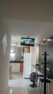 a kitchen with a table and a tv on the wall at LOFT NOVO CONFORTÁVEL in Sorocaba