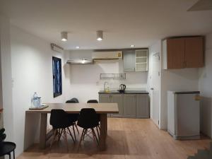 a kitchen with a table and chairs in a room at Srianunt Boutique Hotel in Buriram
