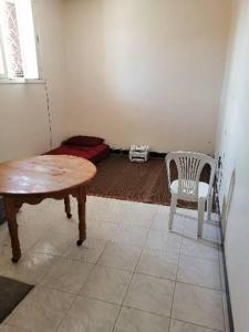 a room with a table and a chair and a bed at Akr appartement in Al Hoceïma