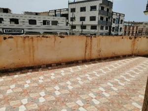 a rusty wall in front of some buildings at Akr appartement in Al Hoceïma