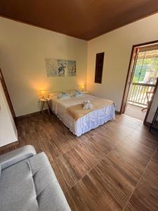 a bedroom with a bed and a couch in it at Agradável Kitnet próximo à Praia do Forte in Mata de Sao Joao