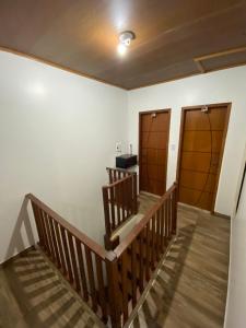 a hallway with two wooden doors and wooden stairs at Agradável Kitnet próximo à Praia do Forte in Mata de Sao Joao +7 photos