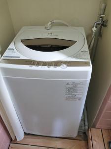 a white toilet with a white seat in a bathroom at Kingfisher Lodge in Shodoshima