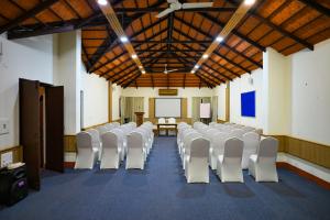 a room with rows of white chairs in a classroom at Kadkani River Resort Coorg in Siddapur +111 photos